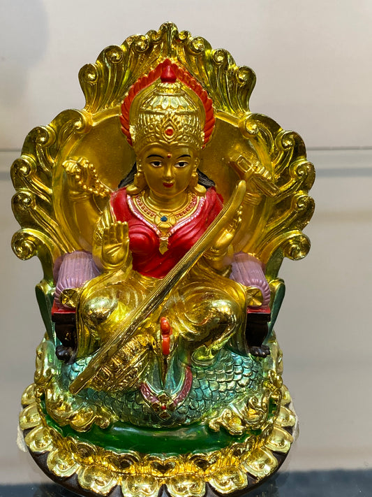 Golden Hindu Goddess Saraswati playing the Veena and sitting on a Swan