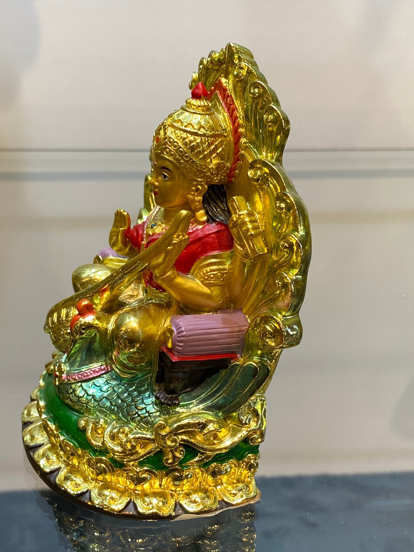 Golden Hindu Goddess Saraswati playing the Veena and sitting on a Swan