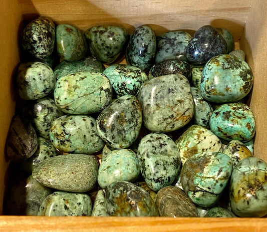 African Turquoise tumbled stones in a box, promoting harmony and peace.