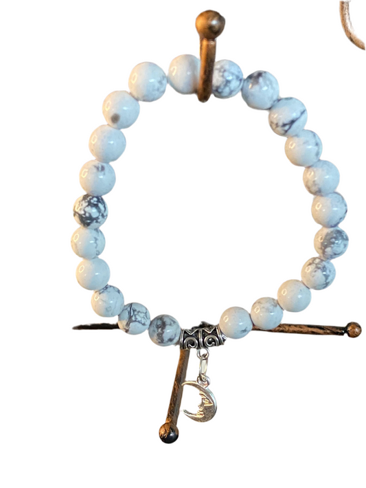 Howlite Gemstone Bracelet with Crescent Moon Charm, symbolizing peace and wisdom.