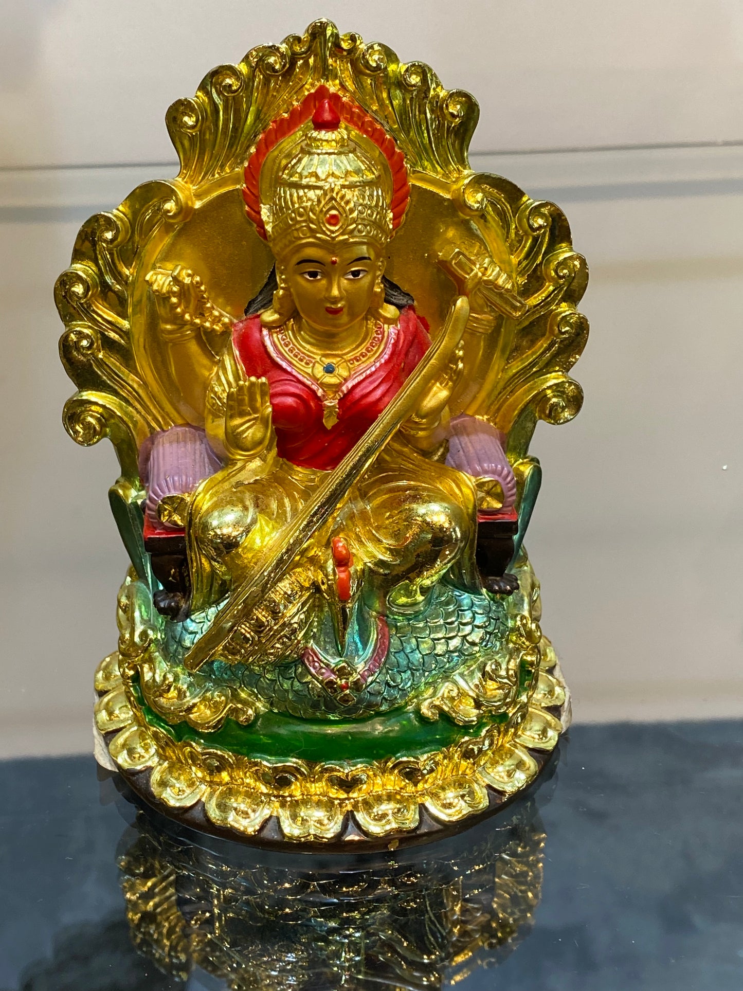 Golden Hindu Goddess Saraswati playing the Veena and sitting on a Swan