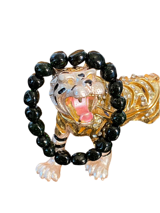 Green Goldstone Beaded String Bracelet with black beads displayed on a decorative tiger figurine.