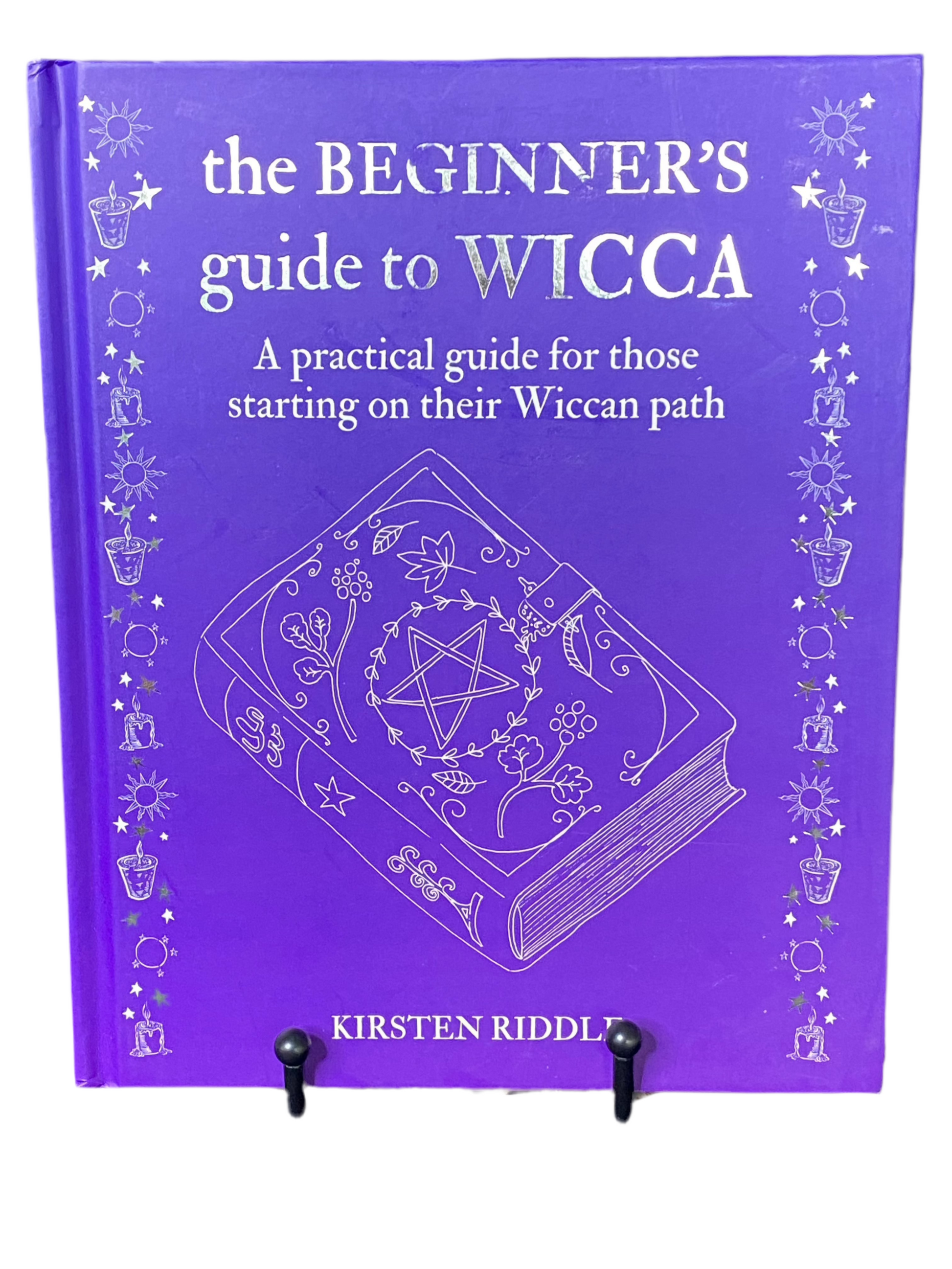 The Beginners Guide to Wicca book cover by Kristen Riddle in purple with magical symbols.