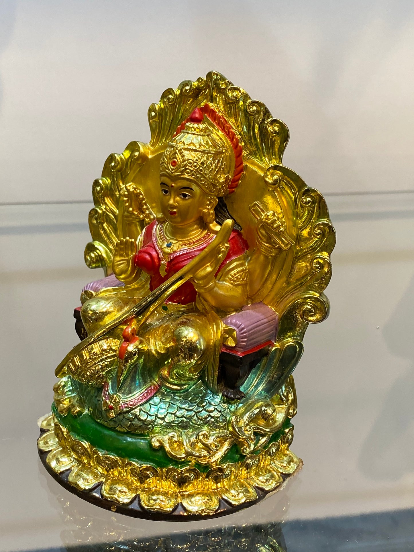 Golden Hindu Goddess Saraswati playing the Veena and sitting on a Swan