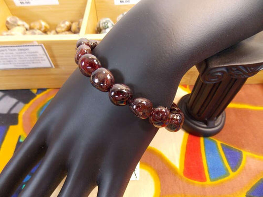 Red Garnet Gemstone Bracelet 8mm with deep red beads on display.