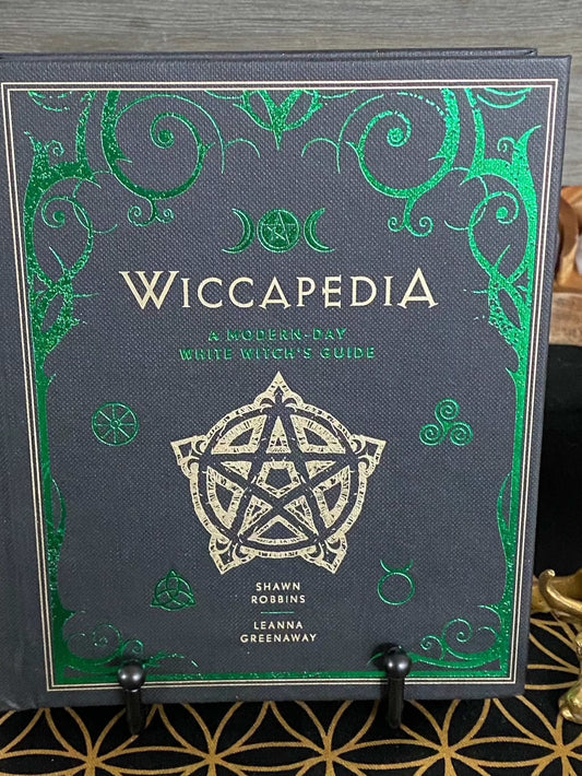 Cover of "Wiccapedia: A Modern-Day White Witch's Guide" by Shawn Robbins & Leanna Greenway, showcasing mystical symbols and green accents.