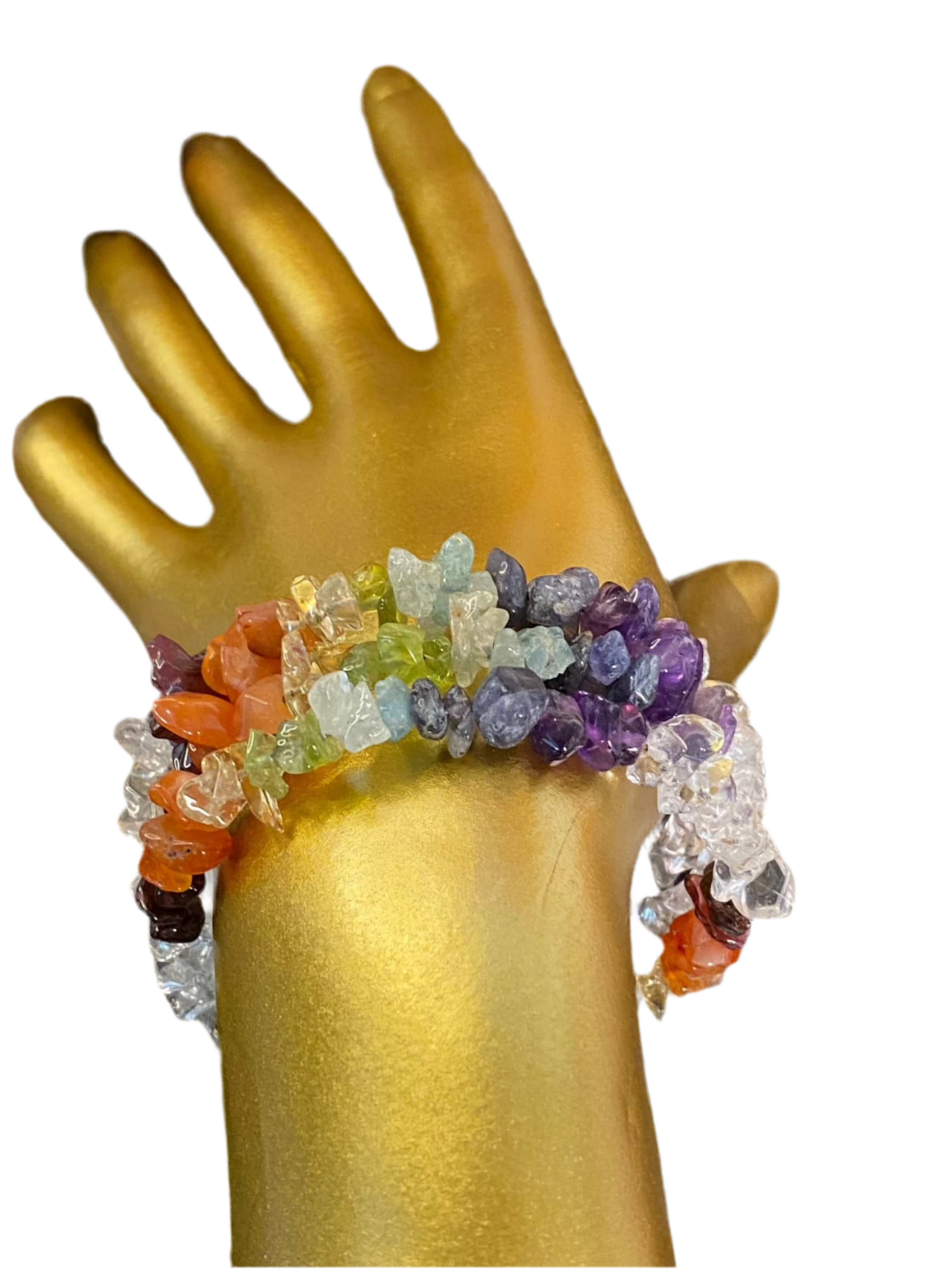 7 Chakra Quartz Elegant Cuff with colorful quartz stones on golden mannequin hand.