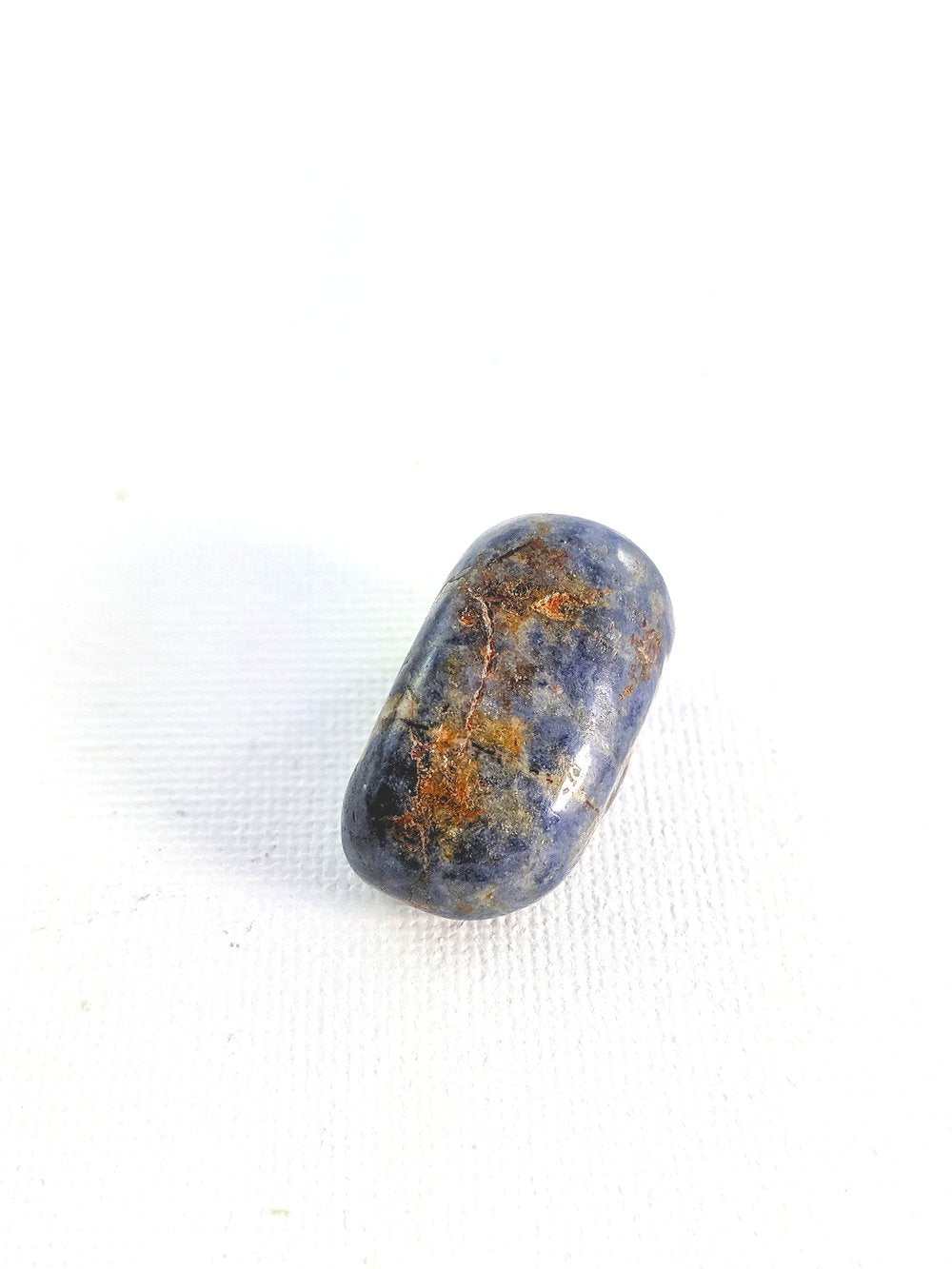 Sapphire Tumbled Stone in blue, known for wisdom, concentration, and creativity.